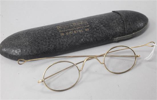 A pair of yellow metal wire-rimmed spectacles, in original opticians case